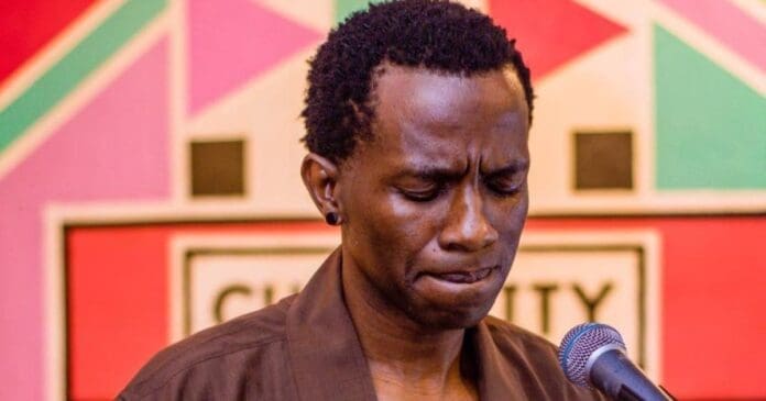 A person stands in front of a microphone with eyes closed, appearing deep in thought, as spiritual voices seem to fill the air against a colorful geometric background.