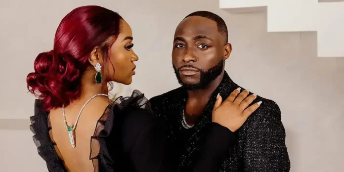 chioma-and-Davido-696x348.webp.webp A woman in a black dress with her hair in an updo stands beside Davido, dressed in a black suit. She faces him while he looks directly at the camera, capturing a moment worthy of the Grammy spotlight.