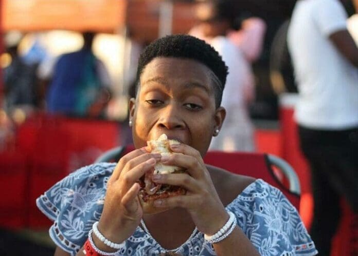 A woman enjoying a hot dog at the Soweto Urban event.