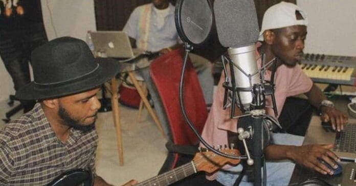 Two men playing guitar in a live recording studio.