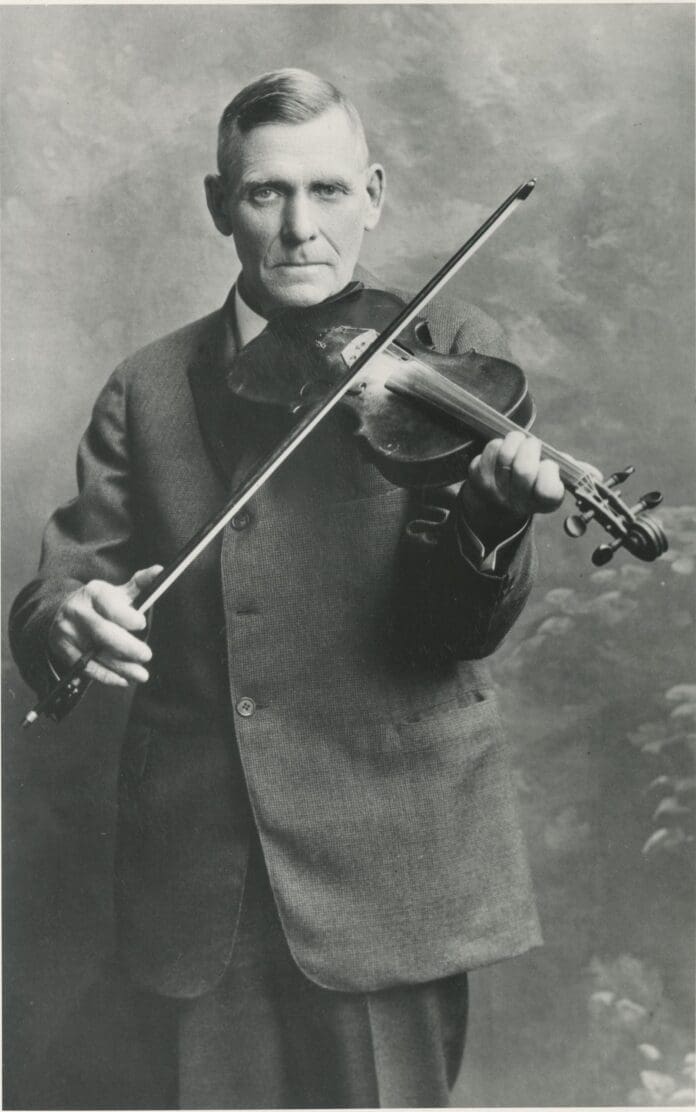 An old photograph of a musician with a violin, showcasing Knox County's history.