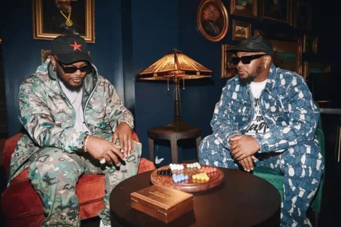 Two men in camouflage outfits sitting at a table.