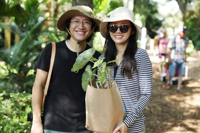 A man and woman holding a plant in a bag featured in the Miami New Times' 18 Best Things to Do in Miami This Week.