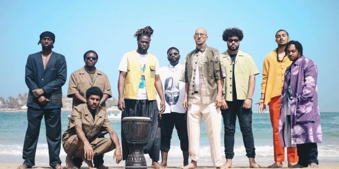 A group of men playing djembe and Manding music on the beach, bound by Balimaya kinship - Pan African Music.