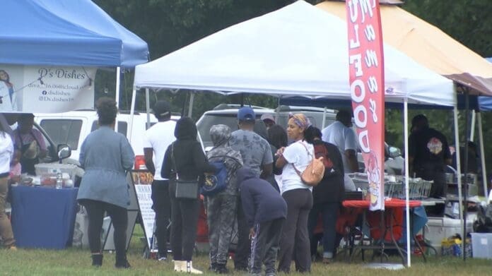 People under tents enjoying BBQ and Gospel music at Stone Soul Festival in Springfield.