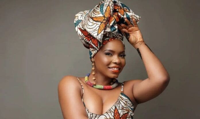 A woman in an African print dress posing for a photo at the Trace Awards nominee reception.