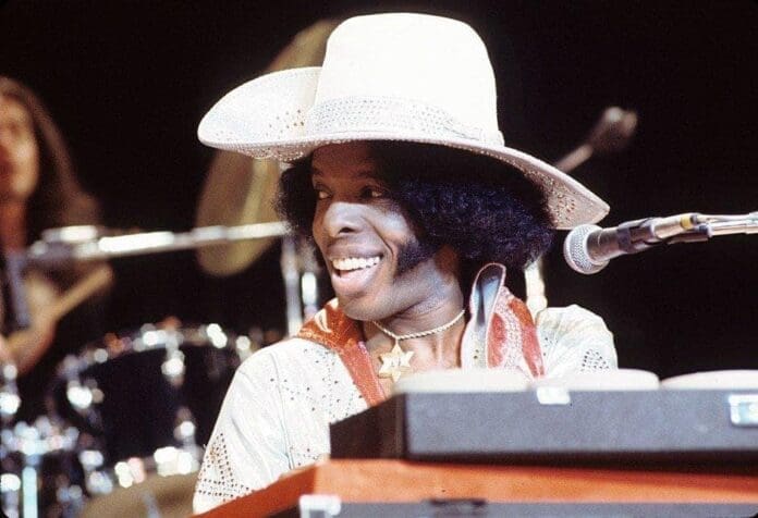 A man in a cowboy hat sitting at a keyboard, reminiscing about his music career.