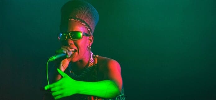 Toya Delazy, a woman in a green hat, singing into a microphone at Beatportal's Playlist of the Week in October 2023.