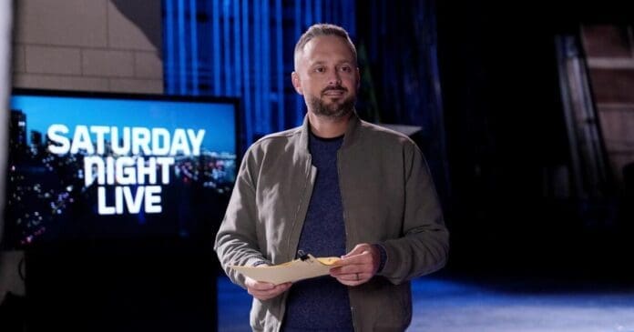 Matthew Perry standing in front of a television with the words SNL.