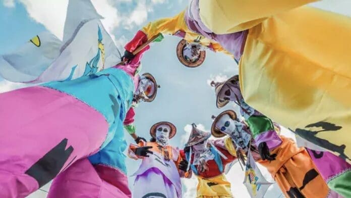 A group of people in colorful costumes celebrating at the Caribbean's Best Christmas Festival.