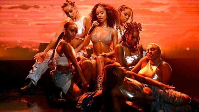 A group of women posing on stage during Tyla's American TV Debut Performance.