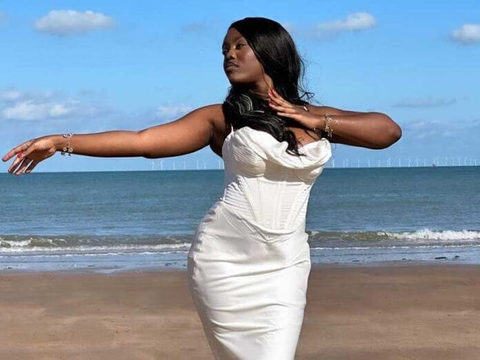 A visually appealing video of a woman in a white dress standing on the beach.