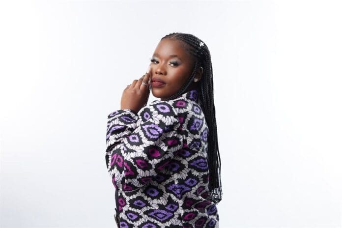 A young woman in a purple jacket, Nobuhle, posing for a photo.