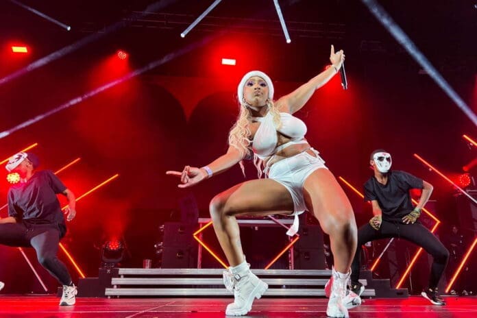 Nicki Minaj performs on stage in a white outfit, showcasing nouveaux styles de musique.